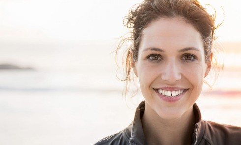 Girl smiling standing in front of the sea